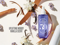 Blue bottle with white cap labeled 'SOL DE JANEIRO' surrounded by flowers and vanilla beans on a light background.