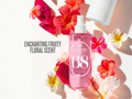Pink spray bottle with floral design and text on a white background