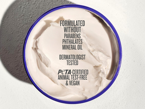 Container of cream with text about product ingredients and certifications on a gray background