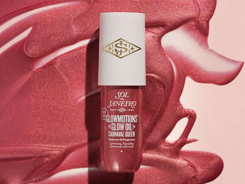 Cosmetic bottle with white cap and red label on a pink textured background