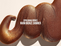 Close-up of a warm bronze shimmer product with 'Copacabana Bronze' text on a beige background