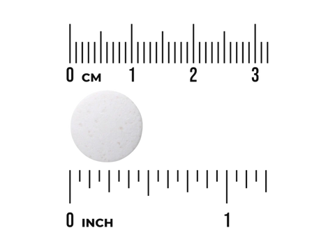White pill with a ruler for scale on a white background