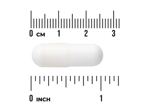 White pill with a ruler for scale on a white background