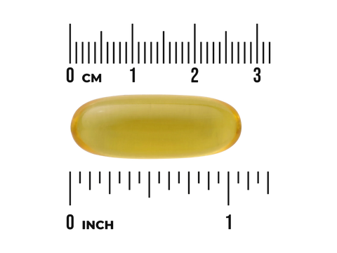 Yellow capsule pill with a ruler for scale on a white background