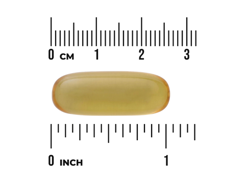Yellow capsule pill with a ruler for scale on a white background