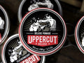 Uppercut Deluxe Pomade 100g front view of styling pomade tin with branding